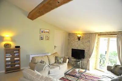 a living room with a couch and a tv at Domaine de Pouroutounat in Mirepoix
