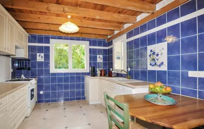 a kitchen with blue tiled walls and a wooden ceiling at Villa tranquille à Montséret avec piscine privée in Montséret