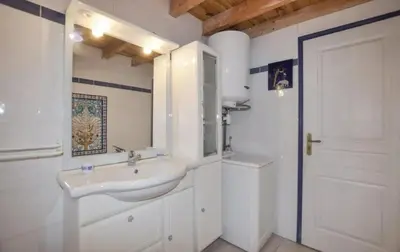 a white bathroom with a sink and a mirror at Villa tranquille à Montséret avec piscine privée in Montséret