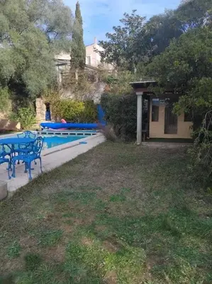 a yard with a blue table and a pool at Villa tranquille à Montséret avec piscine privée in Montséret