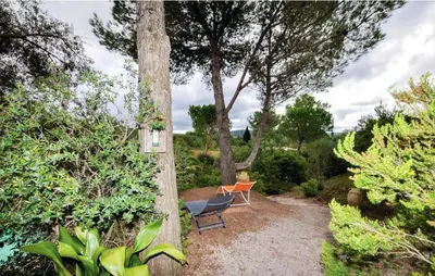 a garden with a chair and a table and trees at Villa tranquille à Montséret avec piscine privée in Montséret