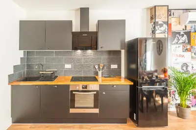 a kitchen with a stove and a refrigerator at L'urbain Narbonnais in Narbonne
