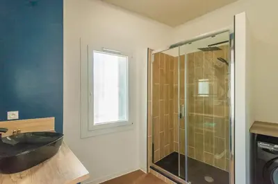 a bathroom with a sink and a glass shower at L'urbain Narbonnais in Narbonne
