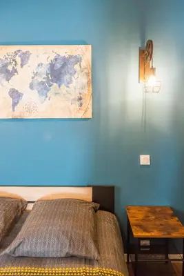 a bedroom with a bed and a table with a map on the wall at L'urbain Narbonnais in Narbonne