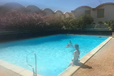 two people are swimming in a swimming pool at Location Nuit Studio Port Gruissan in Gruissan