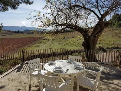 a white table and chairs in front of a tree at Classy Apartment in Villesèque-des-Corbières with Swimming Pool in Villesèque-des-Corbières