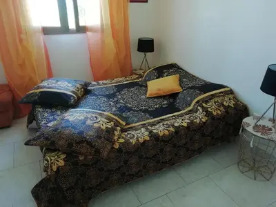 a bed with a blanket and pillows on it at Gîte le pastel in Puéchoursi