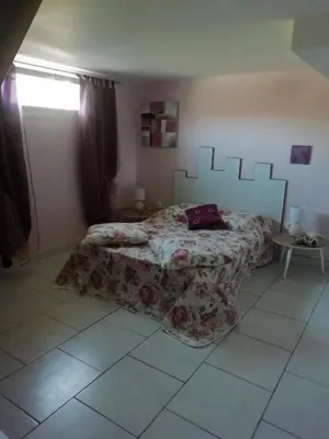 a bedroom with a bed with a bedspread on it at Gîte le pastel in Puéchoursi