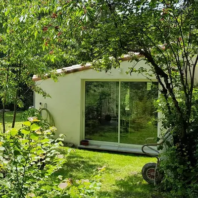 a garden room with a window in a yard at Beautiful studio surrounded by nature in Lanet