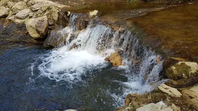 a waterfall on the side of a river at Beautiful studio surrounded by nature in Lanet