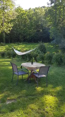 a table and two chairs and a hammock in a yard at Beautiful studio surrounded by nature in Lanet