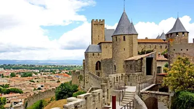 an old castle with a city in the background at Le village-hôtes in Sainte-Vallière