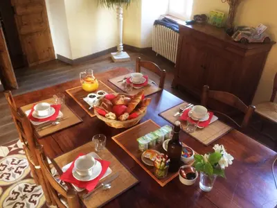 a table with a bowl of fruit on top of it at Le village-hôtes in Sainte-Vallière