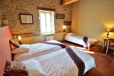 a hotel room with two beds and a window at Le village-hôtes in Sainte-Vallière