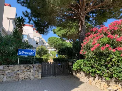 a street sign in front of some bushes and flowers at Appartement avec terrasse au centre de GRUISSAN in Gruissan