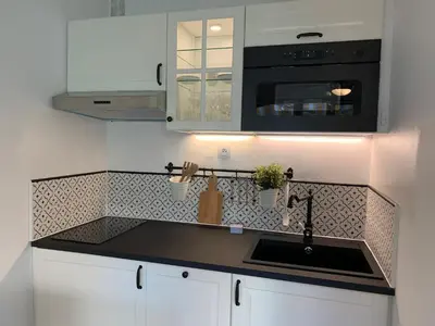 a kitchen with a sink and a microwave at Appartement avec terrasse au centre de GRUISSAN in Gruissan