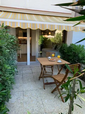 a patio with a wooden table and two chairs at Appartement avec terrasse au centre de GRUISSAN in Gruissan