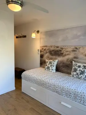 a bedroom with a bed with a painting on the wall at Appartement avec terrasse au centre de GRUISSAN in Gruissan
