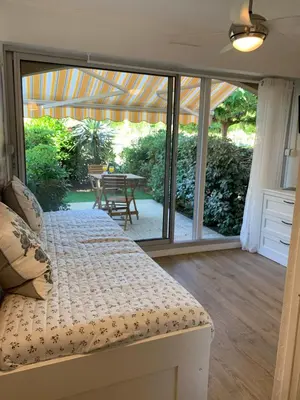 a bedroom with a bed and a patio with a table at Appartement avec terrasse au centre de GRUISSAN in Gruissan