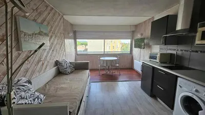 a small kitchen with a couch and a table at Studio plage du Grazel in Gruissan