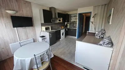 a kitchen with a white table and a table and chairs at Studio plage du Grazel in Gruissan
