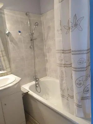 a bathroom with a shower and a white tub at Studio plage du Grazel in Gruissan