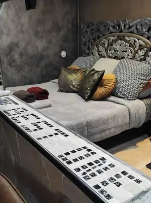 a bed with pillows on it in a room at Drissia&Othman Atipik in Carcassonne