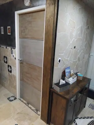 a bathroom with a wooden door in a room at Drissia&Othman Atipik in Carcassonne