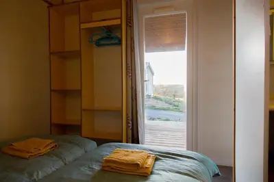 a room with a bed and a window with towels at LES CHALETS D HERMINE in Montredon-Labessonnié