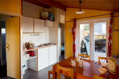a kitchen and dining room with a table and chairs at LES CHALETS D HERMINE in Montredon-Labessonnié