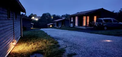 a house with a car parked next to a driveway at LES CHALETS D HERMINE in Montredon-Labessonnié