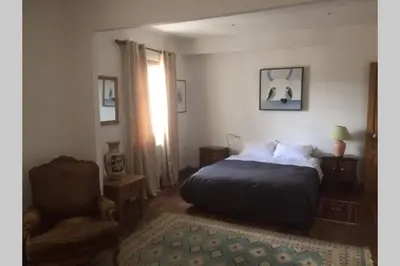 a bedroom with a bed and a chair at Appartement Narada à Limoux in Limoux