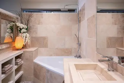 a bathroom with a tub and a shower and a sink at La Remise Penthouse in Le Somail