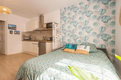 a bedroom with a bed with pillows on it at L'Exotique Narbonnais in Narbonne