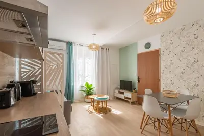 a kitchen and living room with a table and chairs at L'Exotique Narbonnais in Narbonne