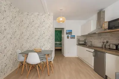 a kitchen and dining room with a table and chairs at L'Exotique Narbonnais in Narbonne