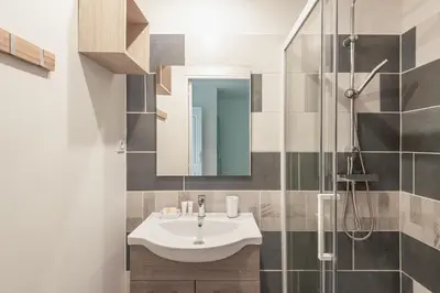 a bathroom with a sink and a shower at L'Exotique Narbonnais in Narbonne