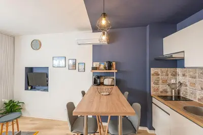 a kitchen and dining room with a wooden table at Le Cosy Narbonnais in Narbonne
