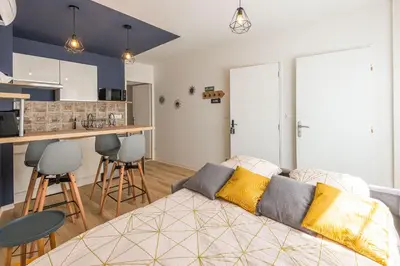 a living room with a couch and a kitchen at Le Cosy Narbonnais in Narbonne