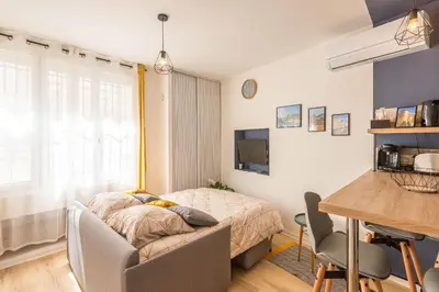 a bedroom with a bed and a desk and a table at Le Cosy Narbonnais in Narbonne