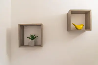 a wall with two niches with a plant and a yellow vase at Le Cosy Narbonnais in Narbonne