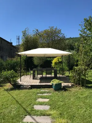 a picnic shelter with a picnic table and a bench at Residence Le petit paradis - La petite maison in Labastide-Rouairoux