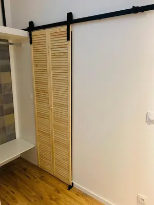 a sliding closet door in a room with wooden floors at L'atypique, La Vue et le Standing du 36 ! Emplacement, clim et extérieur ! in Carcassonne
