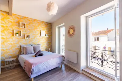 a bedroom with a bed and a large window at AU PIED Du Grand Bassin in Castelnaudary