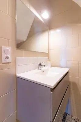 a white bathroom with a sink and a mirror at AU PIED Du Grand Bassin in Castelnaudary