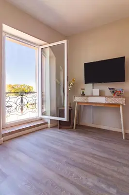a living room with a large window and a flat screen tv at AU PIED Du Grand Bassin in Castelnaudary