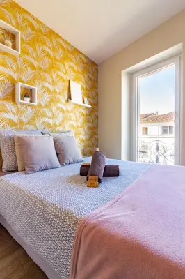 a bedroom with a large bed with a yellow wall at AU PIED Du Grand Bassin in Castelnaudary