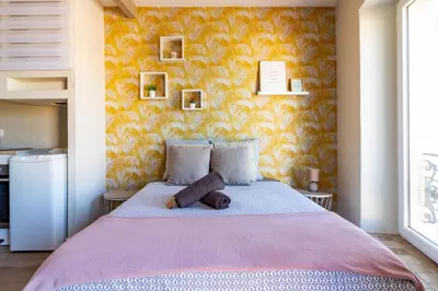 a bedroom with a large bed with a yellow wall at AU PIED Du Grand Bassin in Castelnaudary