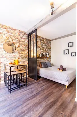 a bedroom with two beds and a dining table at LE COSMO Du Grand Bassin Avec Terrasse in Castelnaudary