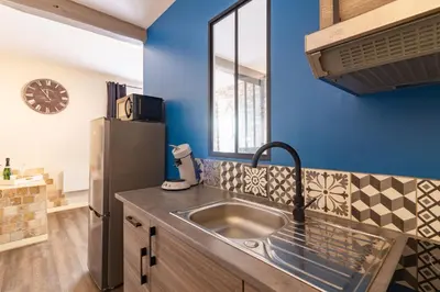 a kitchen with a sink and a refrigerator at LE COSMO Du Grand Bassin Avec Terrasse in Castelnaudary